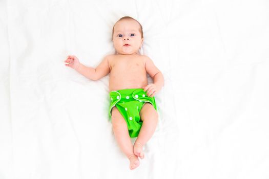 Reusable diaper on the baby copy space . An article about reusable diapers. Saving on diapers. Concern for the environment. Eco-products. Breathable diapers with buttons. High quality photo