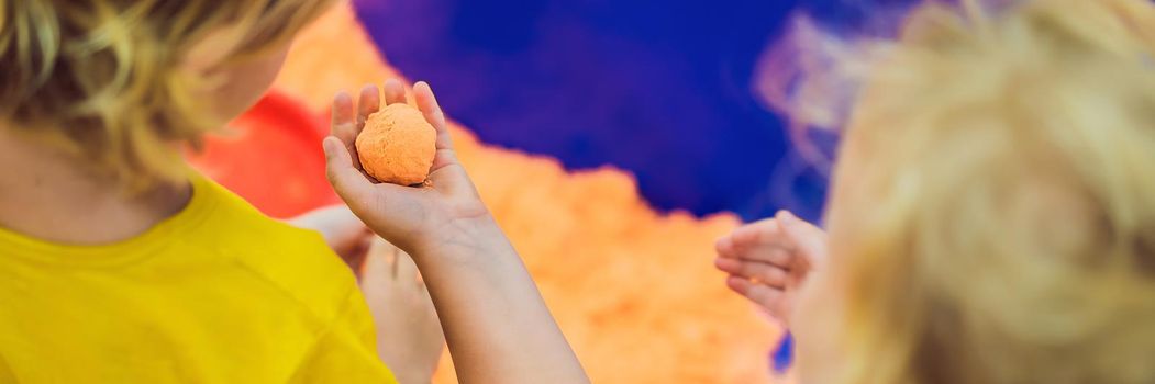 Boy and girl play with kinetic sand. BANNER, LONG FORMAT