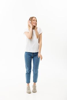 Lifestyle Concept: Portrait of a cheerful happy girl student listening to music with headphones while dancing isolated over white background.