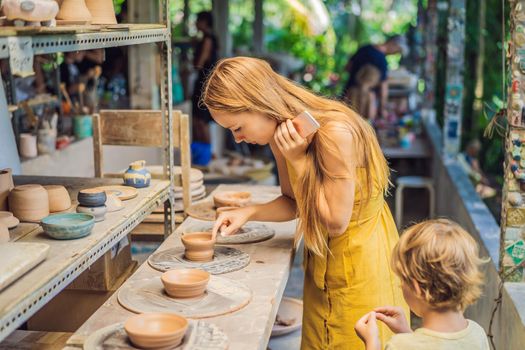 mother and son doing ceramic pot in pottery workshop.