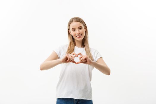 Isolated portrait of beautiful caucasian woman make heart symbol by hands. White studio background. Copy Space
