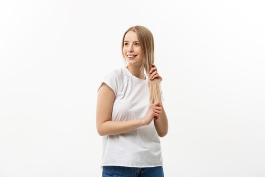 Hair care. Young Caucasian girl combing hair with finger isolated on white background.