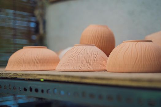 Cups on the shelves in the pottery workshop.