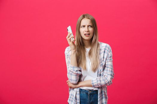 Bored girl calling on the phone and looking crazy on a pink background.