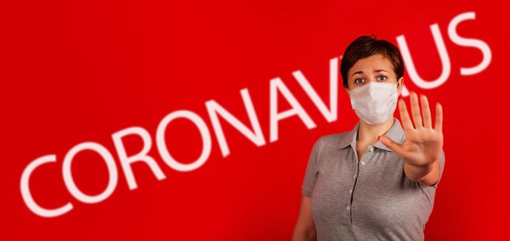 A woman in a mask indicates stopping the spread of the COVID-19 virus. The concept of preventing the spread of the epidemic and treating coronavirus. Coronavirus treatment.