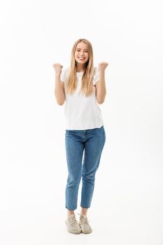 Full-length Portrait of a cheerful woman in white shirt and jean celebrating her success over white background.