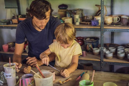 Father and son doing ceramic pot in pottery workshop.