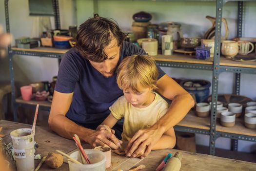 Father and son doing ceramic pot in pottery workshop.