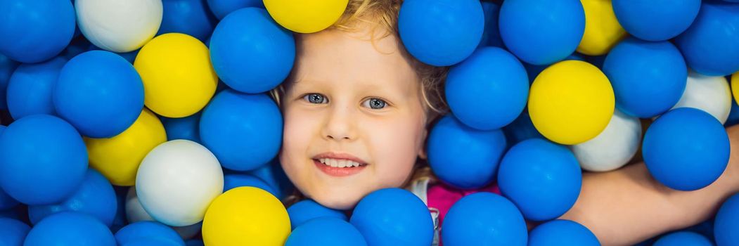 BANNER, LONG FORMAT Child playing in ball pit. Colorful toys for kids. Kindergarten or preschool play room. Toddler kid at day care indoor playground. Balls pool for children. Birthday party for active preschooler.