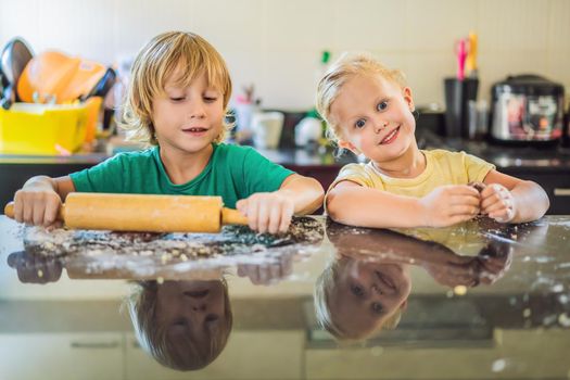 Two children a boy and a girl make cookies from dough.