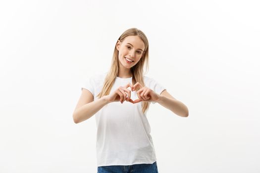 Isolated portrait of beautiful caucasian woman make heart symbol by hands. White studio background. Copy Space