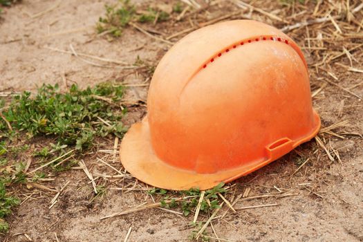 Old building orange helmet on the ground