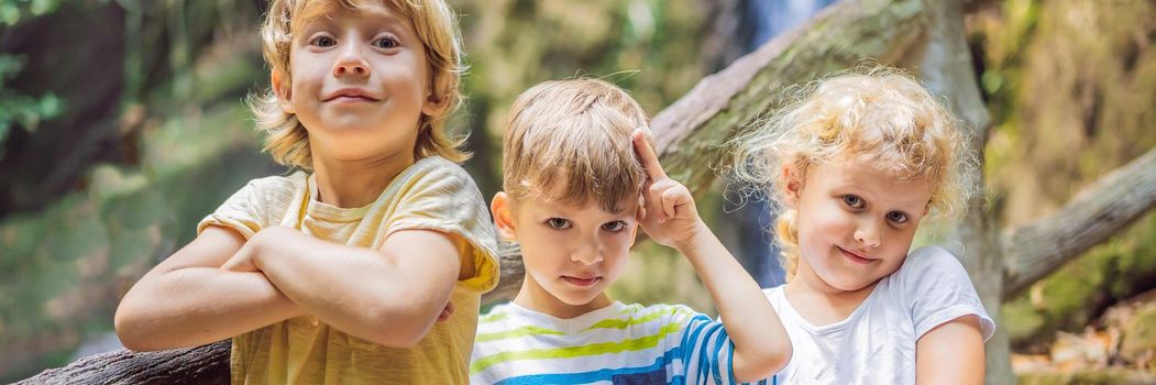 Children rest during a hike in the woods. BANNER, LONG FORMAT