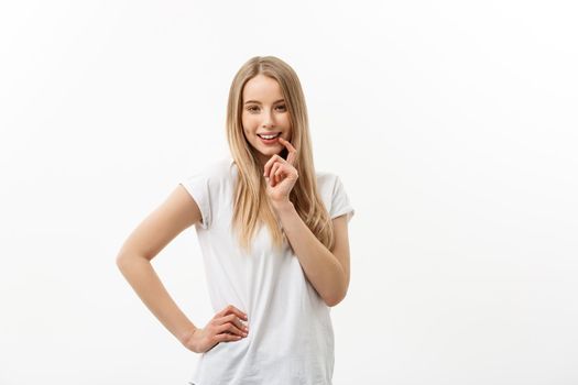 Caucasian young woman with cute adorable playful shy smile. Model white t-shirt isolated on white background.