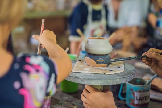 mother and son doing ceramic pot in pottery workshop.