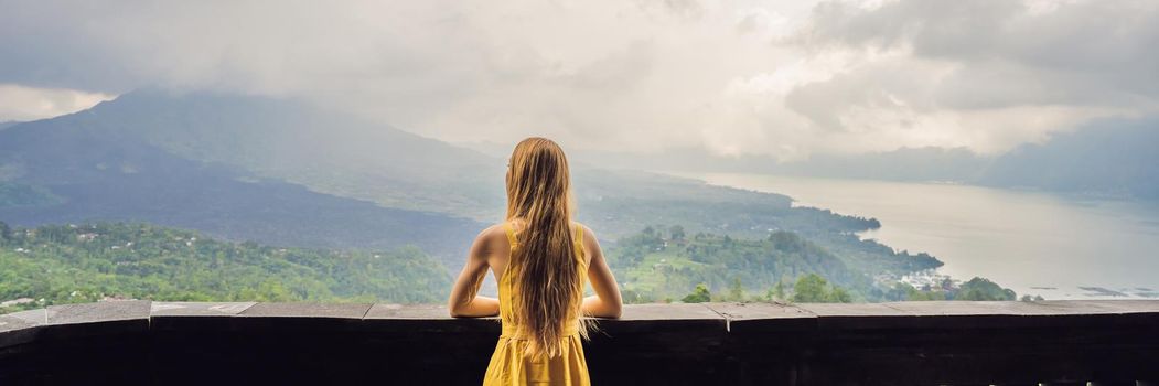 Woman traveler looking at Batur volcano. Indonesia. BANNER, LONG FORMAT