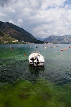 Very beautiful embankment of the Bay of Kotor, a small fishing boat. Montenegro. A beautiful and cozy city, tiled houses. The concept of rest and vacation in Europe