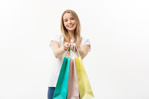 happy attractive caucasian woman offering shopping bags over white background.