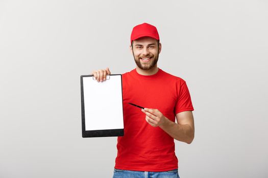 Delivery Concept: Portrait Young caucasian Handsome delivery man or courier showing a confirmation document form to sign. Isolated on Grey studio Background. Copy Space