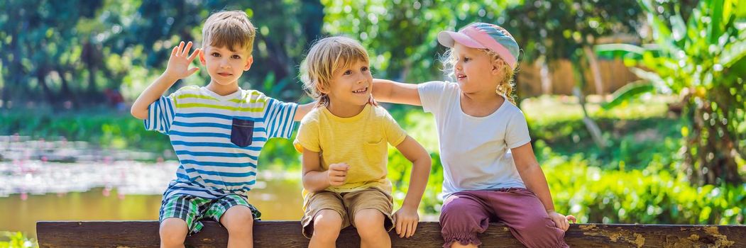 Children rest during a hike in the woods. BANNER, LONG FORMAT