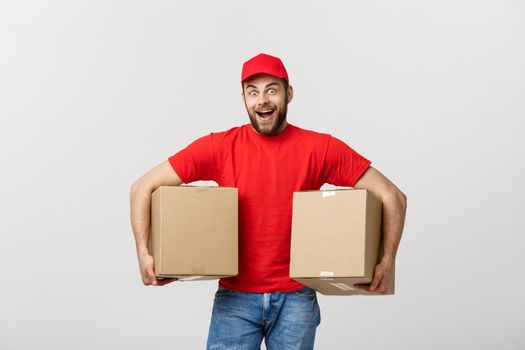 Portrait delivery man in cap with red t-shirt working as courier or dealer holding two empty cardboard boxes. Receiving package. Copy space for advertisement.