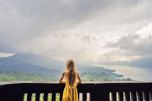 Woman traveler looking at Batur volcano. Indonesia.