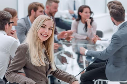 smiling young woman sitting at table in conference room . business concept