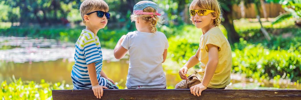 Children rest during a hike in the woods. BANNER, LONG FORMAT