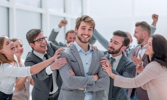 close up. cheerful company employees applauding their colleague. success concept