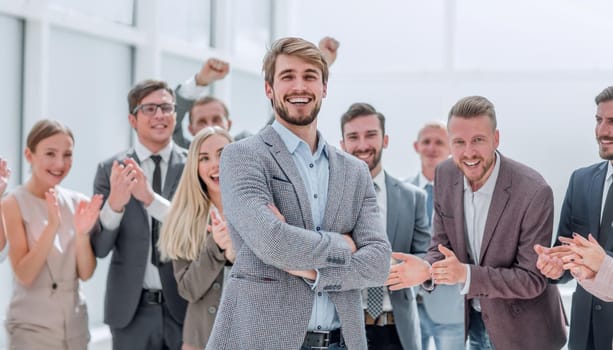 close up. cheerful company employees applauding their colleague. success concept