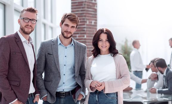 three young employees standing in a modern office. photo with copy space