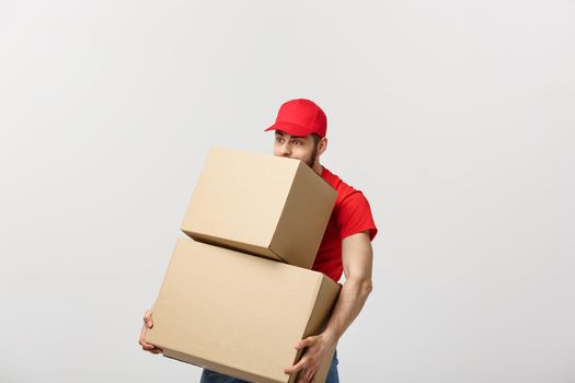 Delivery man doing surprise gesture holding cardboard boxes