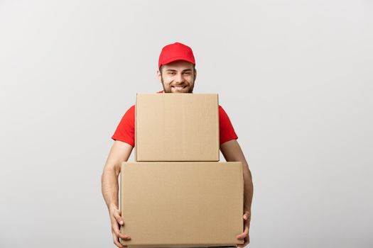 Delivery man doing surprise gesture holding cardboard boxes