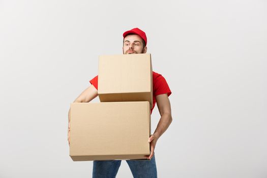 Delivery man doing surprise gesture holding cardboard boxes