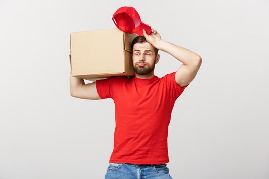 Delivery Concept: handsome Delivery man with boxes, delivery, courier with worry facial expression. Isolated grey background