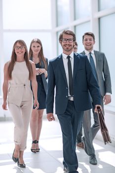 businessman walking in front of his business team . business concept