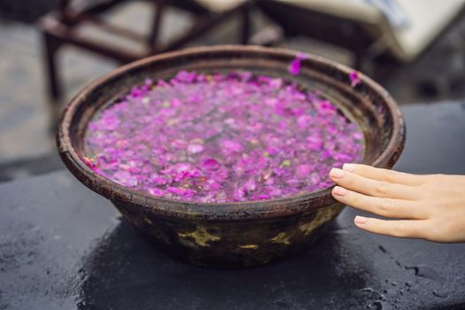 Balinese basin with flower petals on the background of the pool.