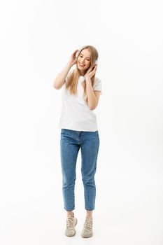 Lifestyle Concept: Portrait of a cheerful happy girl student listening to music with headphones while dancing isolated over white background.