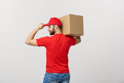 Portrait delivery man in cap with red t-shirt working as courier or dealer holding two empty cardboard boxes. Receiving package. Copy space for advertisement.