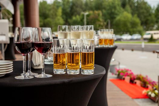 Glasses with juice, glasses with red wine on a buffet table.