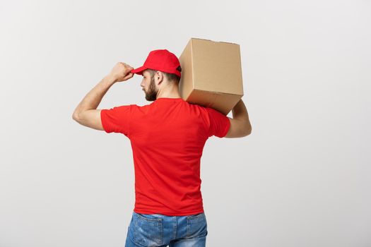 Portrait delivery man in cap with red t-shirt working as courier or dealer holding two empty cardboard boxes. Receiving package. Copy space for advertisement.