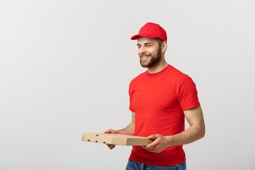 Delivery Concept: Young haapy caucasian Handsome Pizza delivery man holding pizza boxes isolated over grey background.