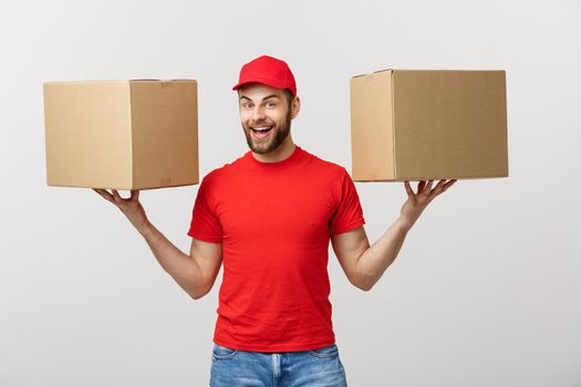 Portrait delivery man in cap with red t-shirt working as courier or dealer holding two empty cardboard boxes. Receiving package. Copy space for advertisement.