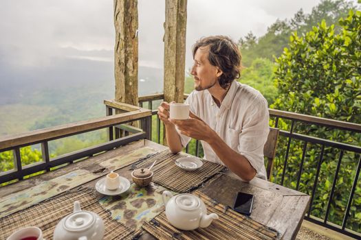 Man drinking tea in a cafe in the mountains.