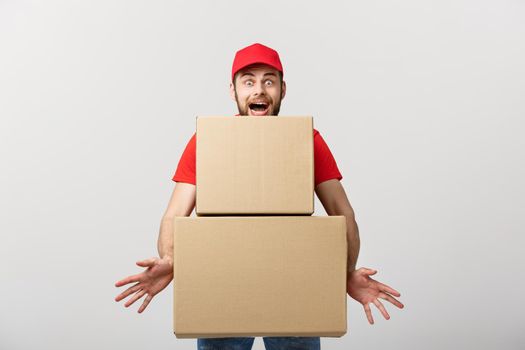 Delivery man doing surprise gesture holding cardboard boxes