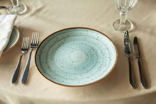 A beautiful plate on the table with forks and knives.