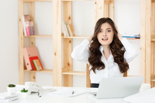 Young pretty business woman with notebook and document in the bright modern office indoors.