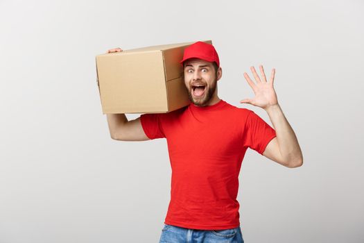 Delivery man doing surprise gesture holding cardboard boxes