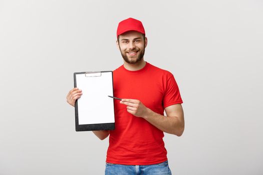Delivery Concept: Portrait Young caucasian Handsome delivery man or courier showing a confirmation document form to sign. Isolated on Grey studio Background. Copy Space