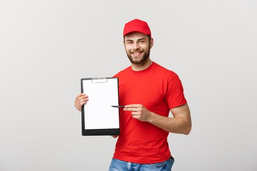 Delivery Concept: Portrait Young caucasian Handsome delivery man or courier showing a confirmation document form to sign. Isolated on Grey studio Background. Copy Space
